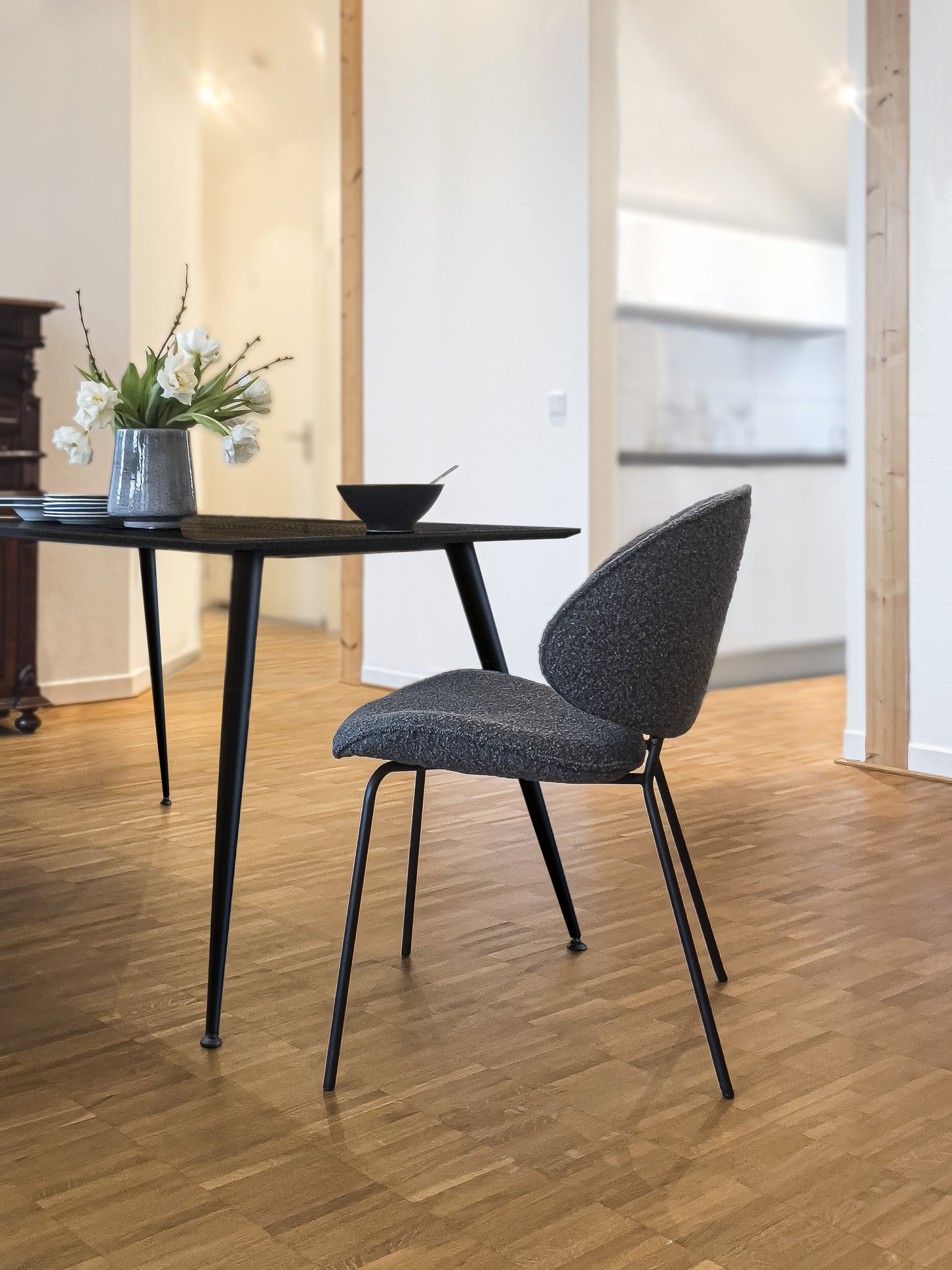 Alvaro chair in dark grey bouclé at black table