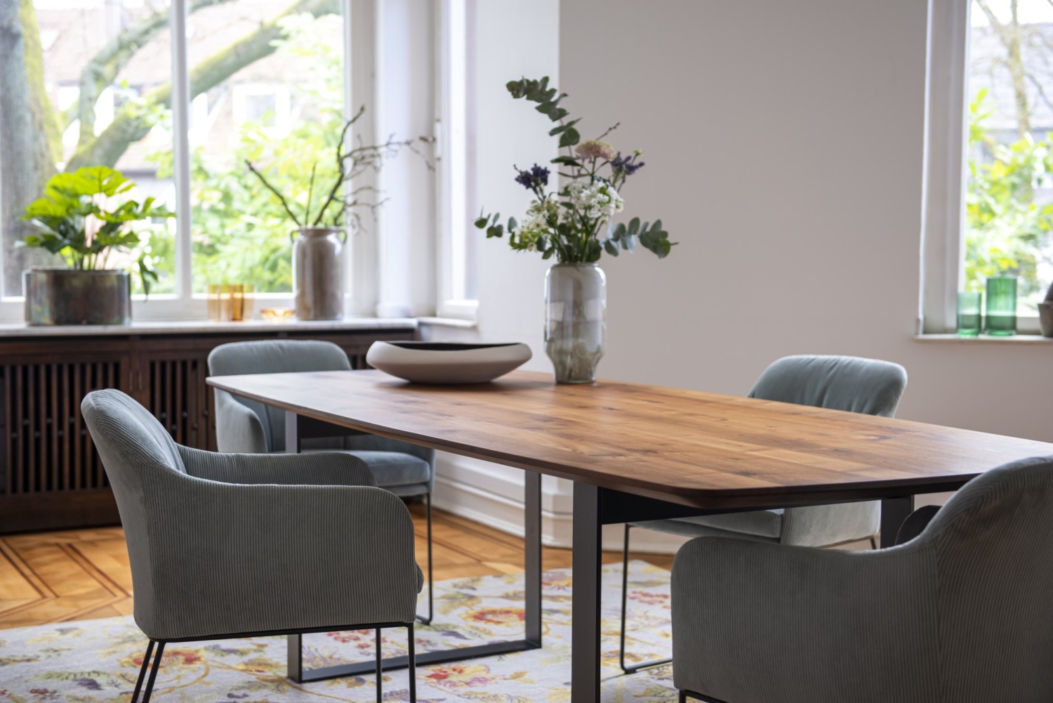 Light blue Youma casual chairs KFF at the Uno table ASCO on a floral rug