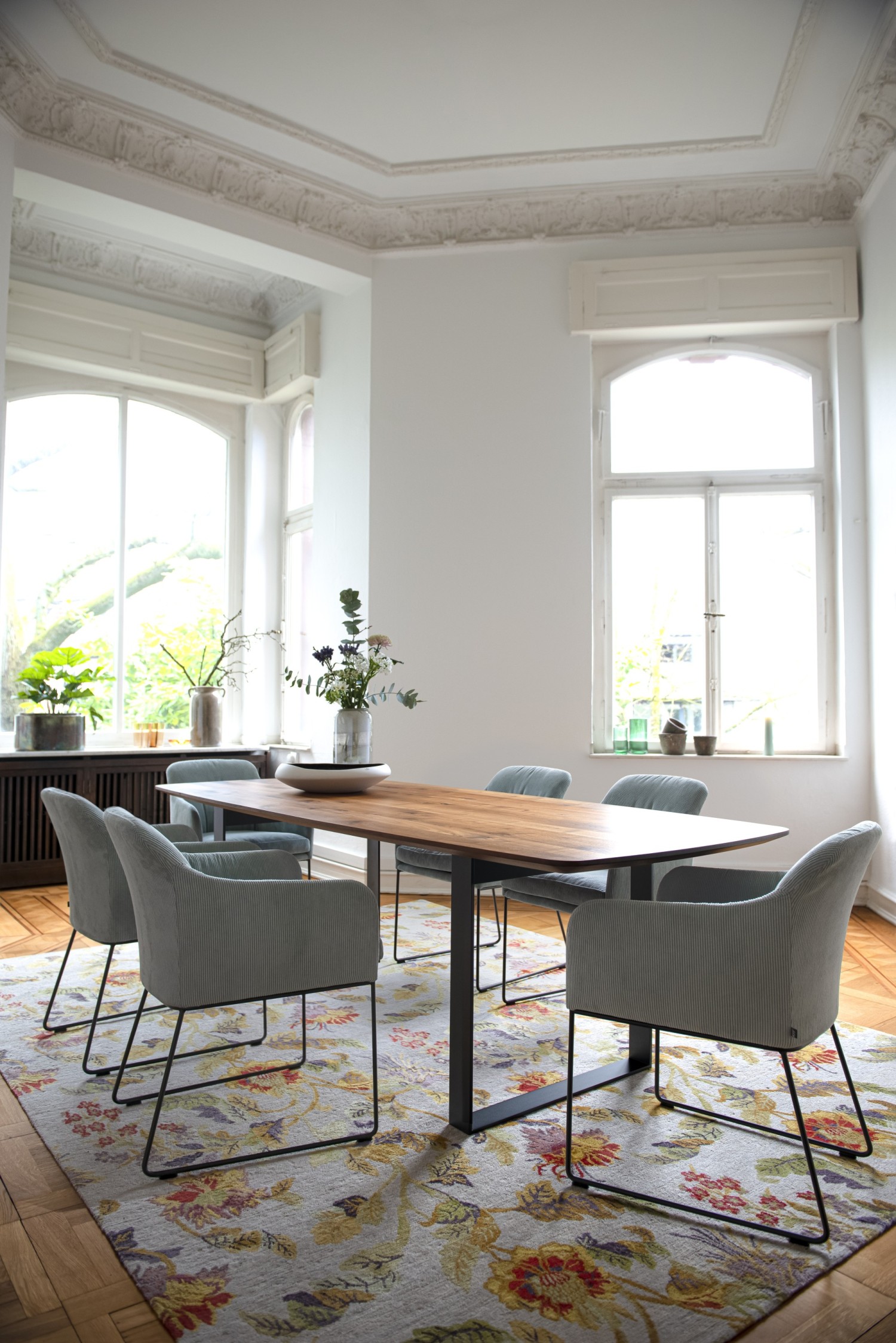 Light blue Youma casual chairs KFF at the Uno table ASCO on a floral rug