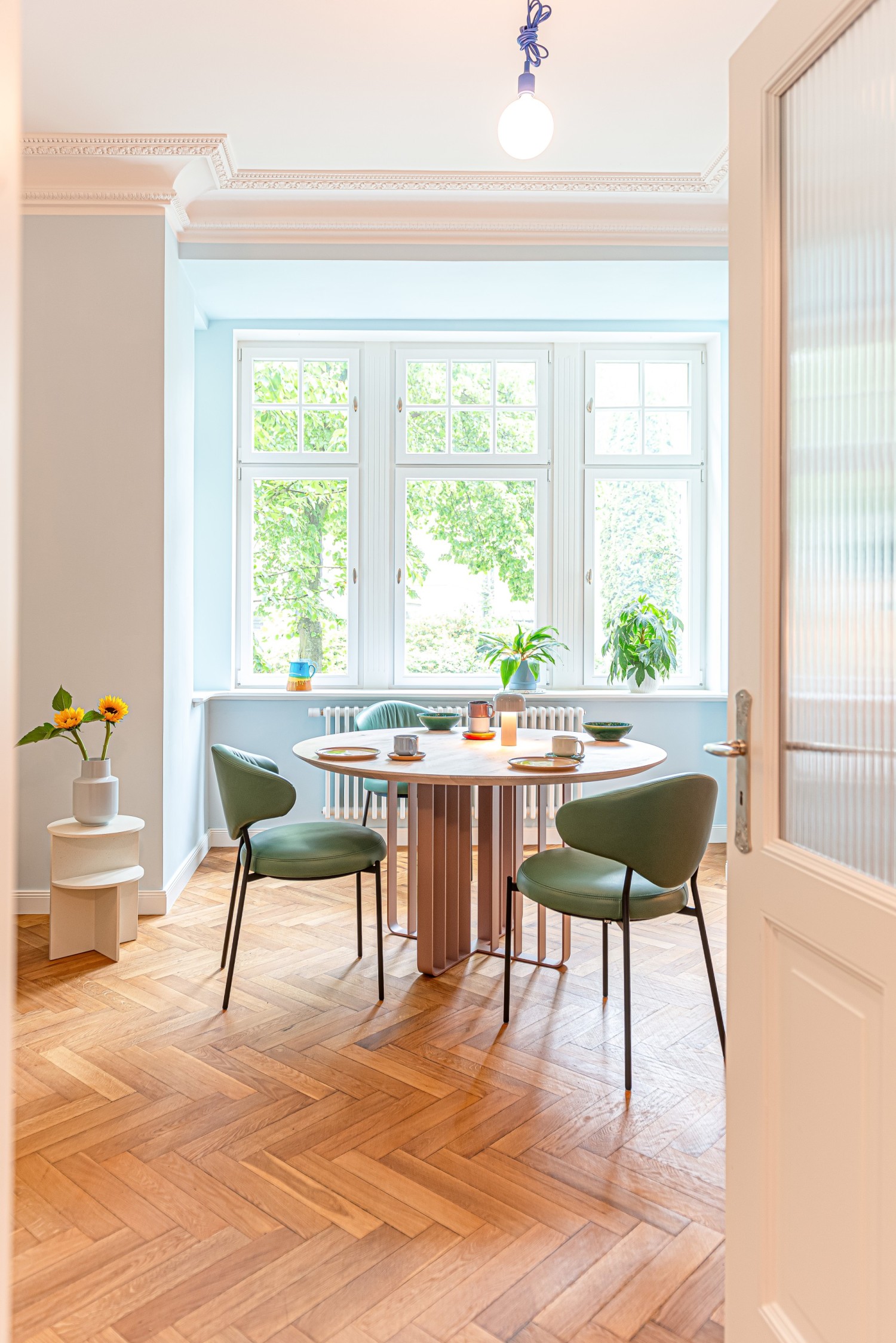 ICON chair in emerald leather at the ASCO Lamello round table in a modern kitchen.