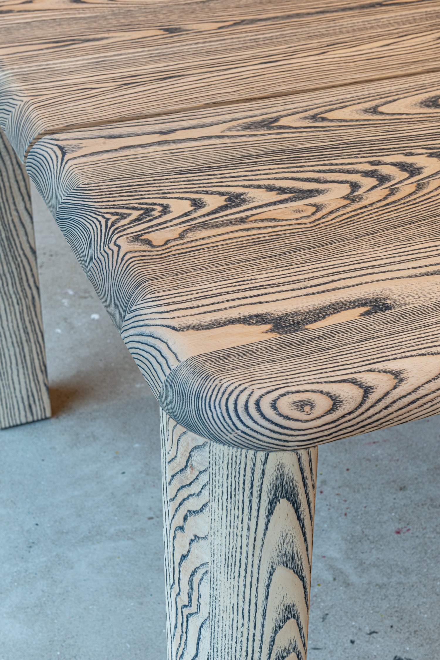 Detailaufnahme der runden Tischecke. Forte Tisch von ASCO in kontrastreicher Escheplatte.